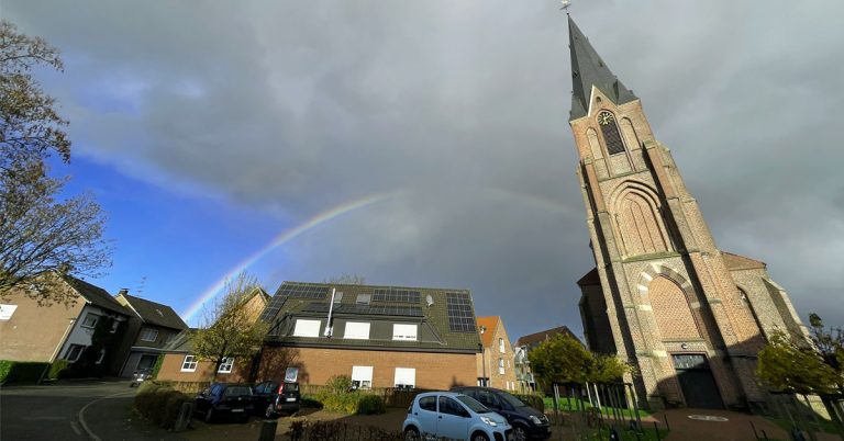 Die Silvesterkirche im Dorf Erle im westlichsten Zipfel des Münsterlandes Münsterland beleuchtet von einem Regenbogen
