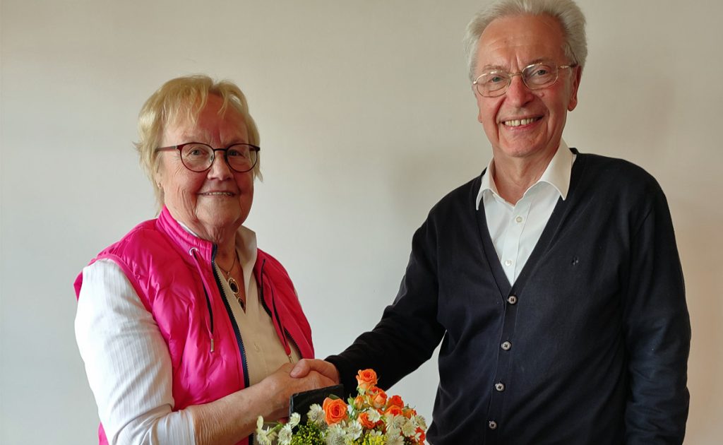 Hildegard Gülker wird vom Vorsitzenden Carlo Behler mit Blumenstrauß und Dankestafel beim Heimatverein Erle verabschiedet