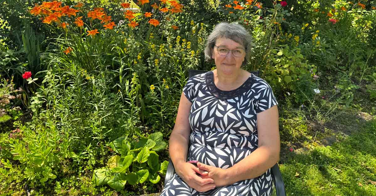 Edith Liesner sitzt auf einer Bank in ihrem naturnahen Garten in Raesfeld.