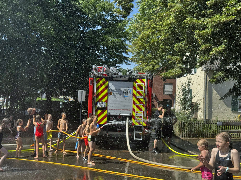 Feuerwehr sorgt mit Wasser auf dem Schulhof der Silvesterschule Erle für Erfrischung bei den Schulkindern.
