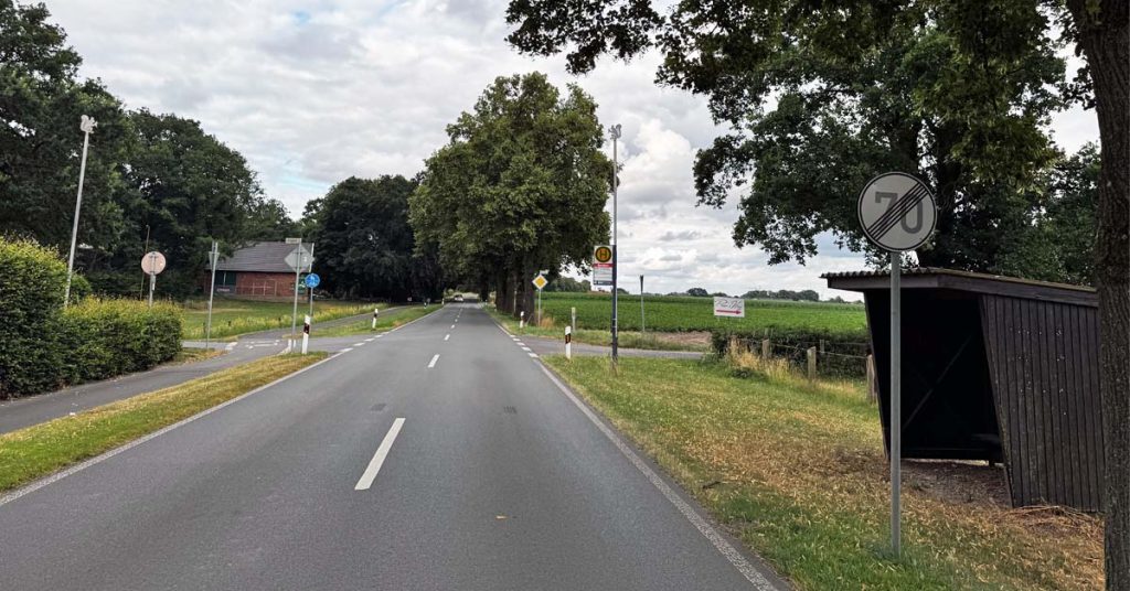 Blick auf die Marienthaler Straße in Raesfeld-Erle mit einer Bushaltestelle am Fahrbahnrand. Die Straße steht im Mittelpunkt der Diskussion um die Schülerbeförderung zur Silvesterschule.