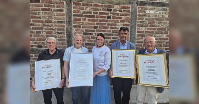 Bäckermeister und Julia Imping stehen mit Goldenen und Silbernen Meisterbriefen vor einer Backsteinwand