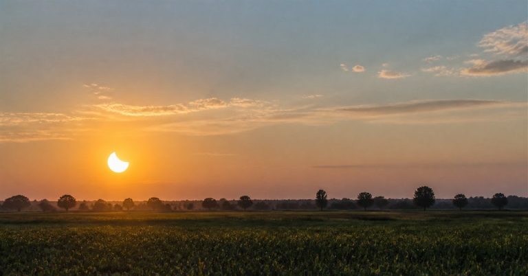 Partielle Sonnenfinsternis über freiem Feld bei Sonnenuntergang Raesfeld