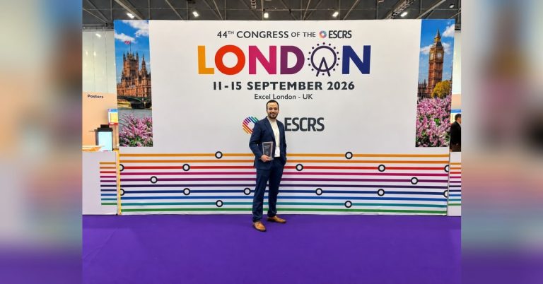 Labib Alshaweesh steht mit Auszeichnung vor der ESCRS-Wand in London