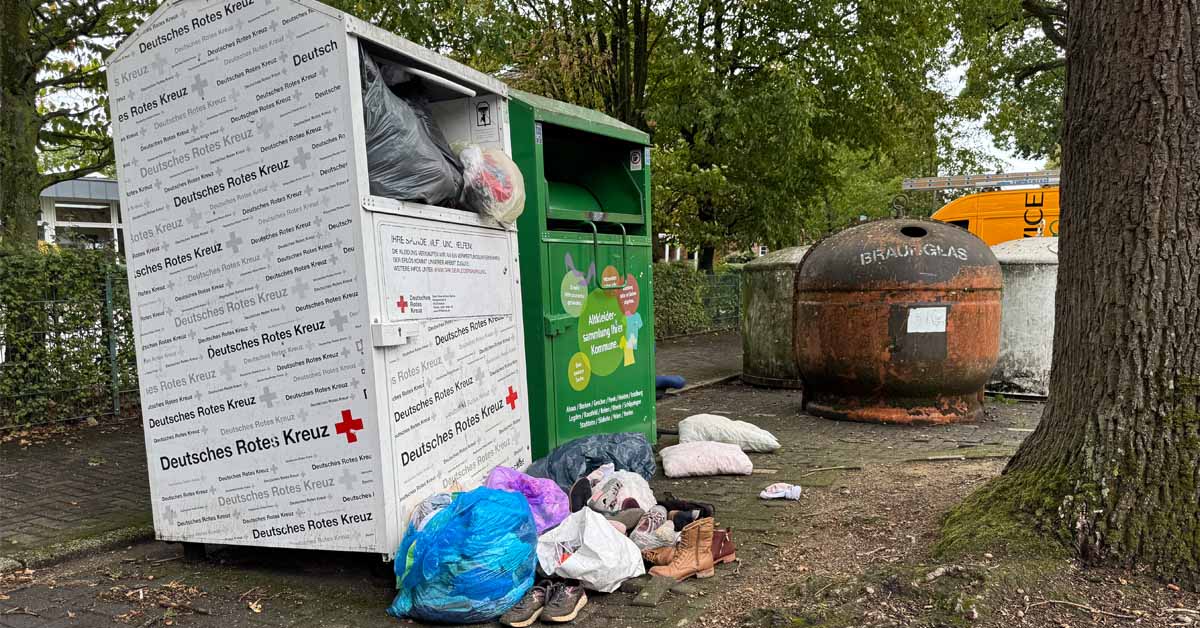Kleidung und Müll vor dem Altkleidercontainer in Erle