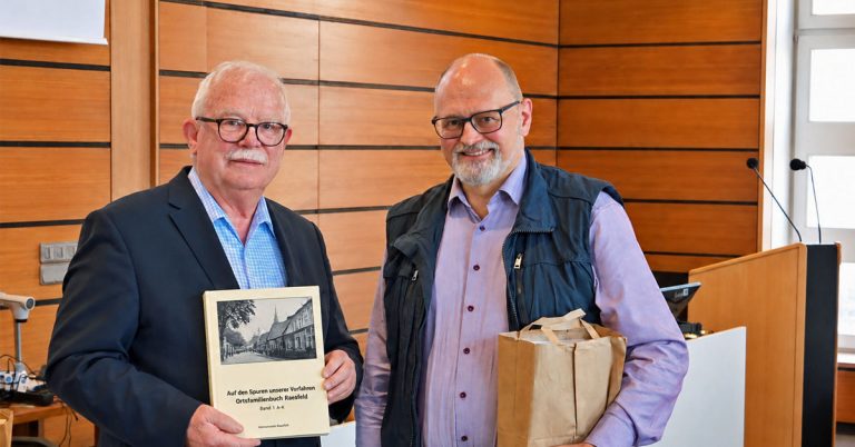 Karl-Heinz Tünte und Josef Schnieder präsentieren das neue Ortsfamilienbuch Raesfeld im Rathaus.
