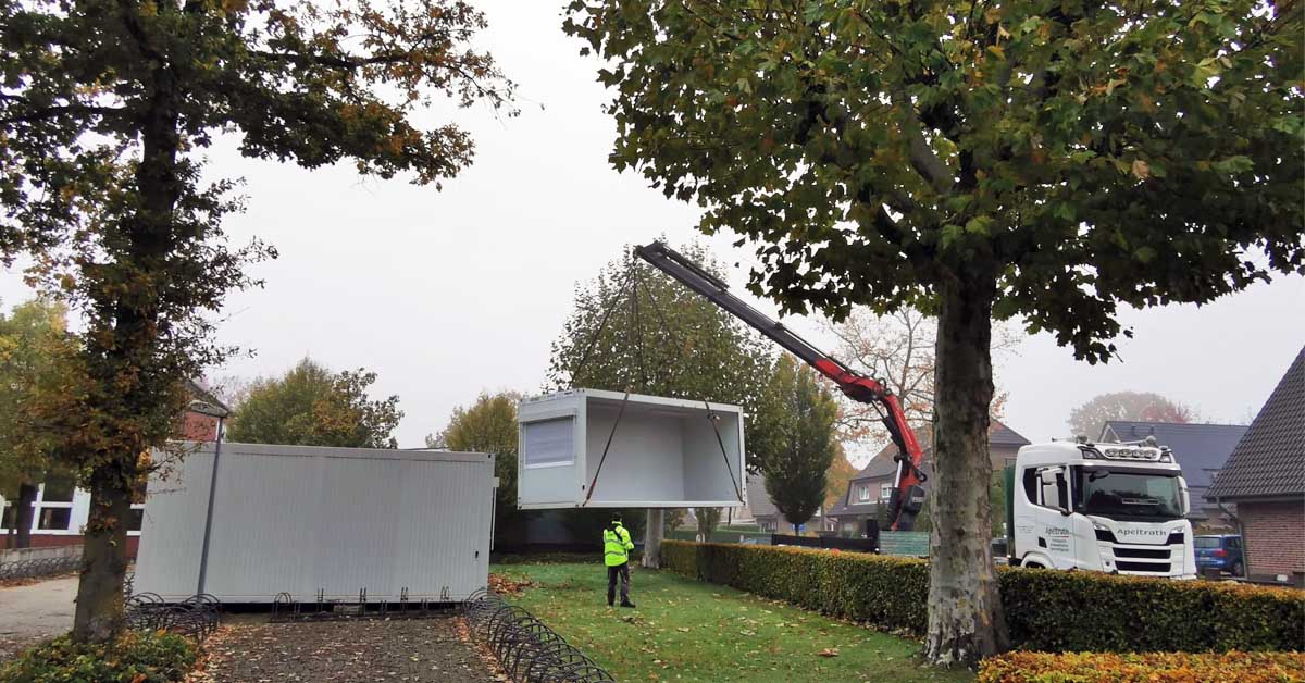 Container hängt beim Abbau an der Sebastianschule in Raesfeld am Kranhaken